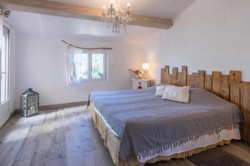 a bedroom with a large bed and a chandelier at Villa les cigales in Le Thoronet
