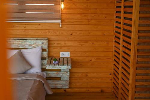 a bedroom with wooden walls and a bed with a night stand at Le Parc des Oliviers in Marrakech