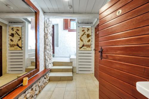 uma casa de banho com uma porta de madeira e uma banheira em Private Villa Core Croatia em Murter