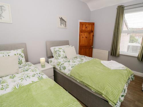 a bedroom with two beds and a window at 1 River View Terrace in Llandudno Junction