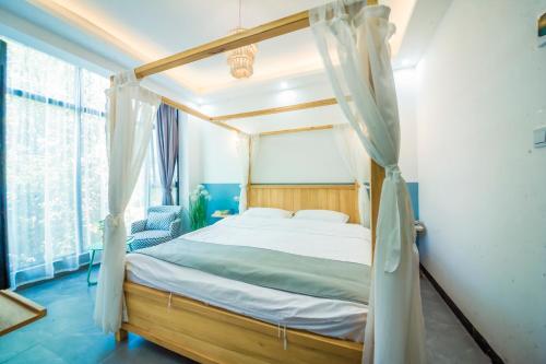 a bedroom with a canopy bed and a window at Yixun Inn in Zhangjiajie