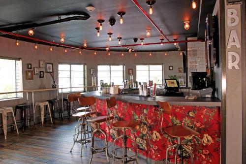 a bar with red chairs and a counter in a restaurant at Hotel Gaythering - Gay Hotel - All Adults Welcome in Miami Beach