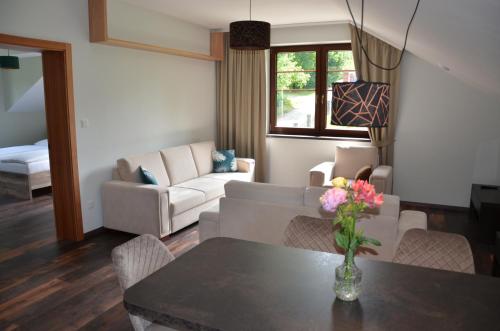 a living room with a couch and a table with flowers at FloraVilla in Rajecké Teplice