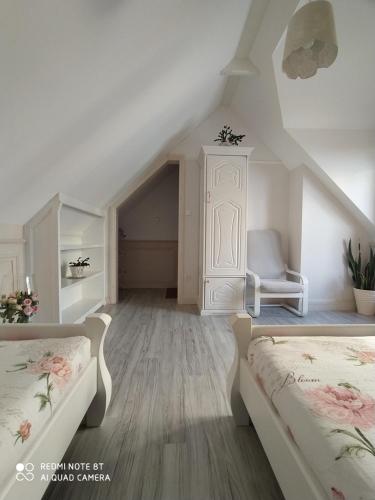 un dormitorio en el ático con 2 camas y una silla en Willa Grono en Krościenko