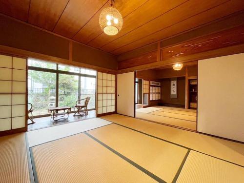 an empty room with a table and chairs in a building at 1棟貸切宿 木曽家旅館 しまなみ海道最初の島 supported by COCOSTAY in Onomichi