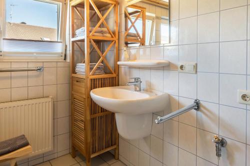 ein Bad mit einem Waschbecken und einem Spiegel in der Unterkunft Haus Unterseeblick - Sonnenaufgang in Gaienhofen