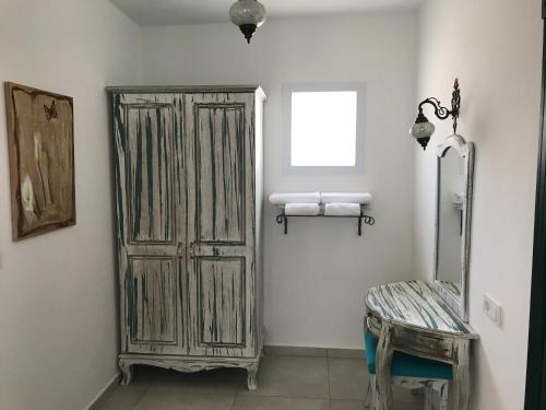 a bathroom with an old wooden cabinet and a window at Bahama Art Hotel in Turgutreis