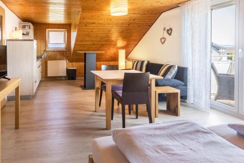 Zimmer mit einem Tisch und einem Esszimmer in der Unterkunft Haus Unterseeblick - Sonnenaufgang in Gaienhofen
