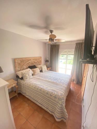 een slaapkamer met een bed en een plafondventilator bij Casa adosada Huerta del Prado in Marbella
