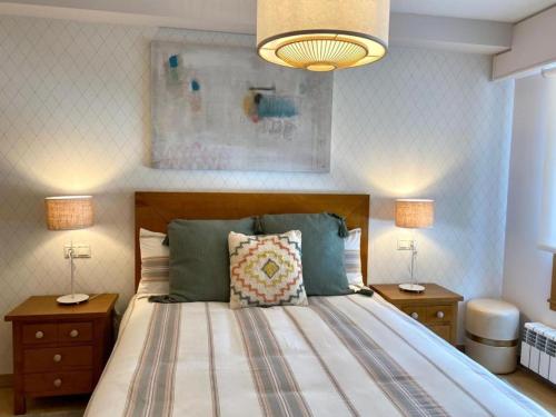 1 dormitorio con 1 cama con 2 mesitas de noche y 2 lámparas en Andainas Apartamentos Turísticos B en Milladoiro