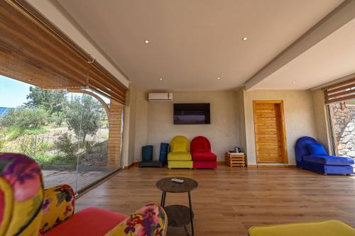 a living room with colorful chairs and a flat screen tv at Le Parc des Oliviers in Marrakech