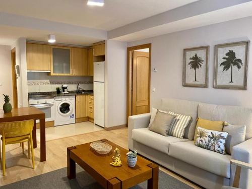 sala de estar con sofá y mesa en Andainas Apartamentos Turísticos B en Milladoiro