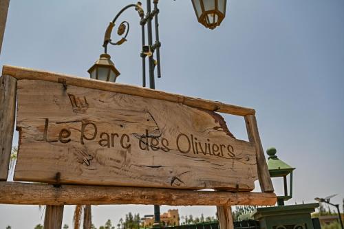a wooden sign that reads le dance for outsiders at Le Parc des Oliviers in Marrakech