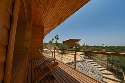 a wooden deck with a chair on a house at Le Parc des Oliviers in Marrakech