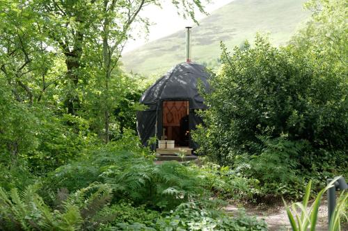 ein schwarzes Kuppelhaus inmitten eines Gartens in der Unterkunft Eastside Byre - Family cottage in the Pentland Hills near Edinburgh in Penicuik
