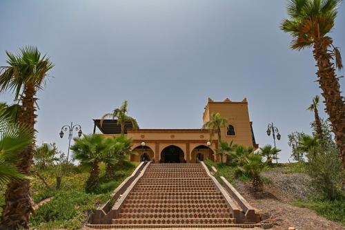 a building with steps leading up to a building with palm trees at Le Parc des Oliviers in Marrakech
