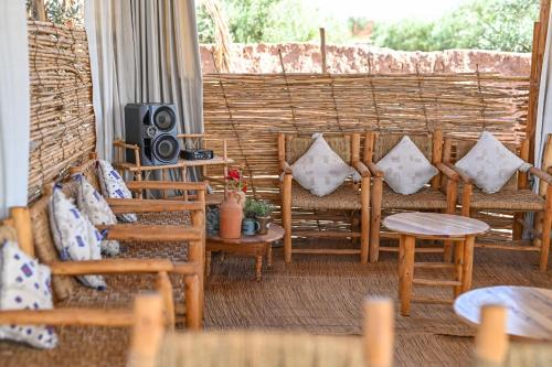 a porch with chairs and a television and a table at Le Parc des Oliviers in Marrakech