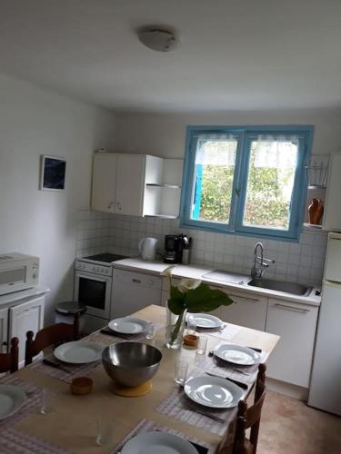 une cuisine avec une table avec des assiettes dessus dans l'établissement Kerleuquer Ty Nevez, à Plobannalec-Lesconil
