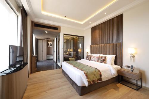 a bedroom with a bed and a flat screen tv at Fortune Ranjit Vihar, Amritsar- Member ITC's hotel group in Amritsar