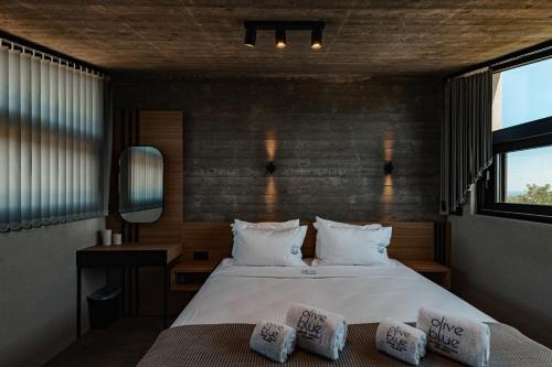 a bedroom with a bed with two pillows on it at olive blue thassos luxury villas in Astris