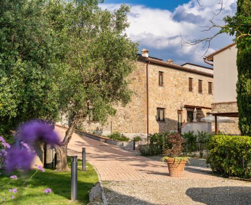 a stone building with a tree and a sidewalk at TORREVISTA - Opened 2022 in Montaione