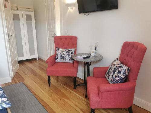 庫克斯港的住宿－德赫沃吉酒店，客厅配有两把椅子和一张桌子