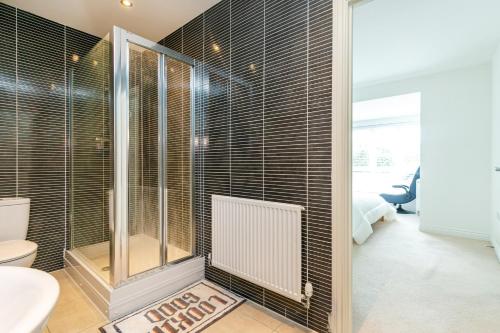 a bathroom with a shower and a toilet at `isimi Ashford Kent [ Modern New Built 4 Bedroom House ] in Kent
