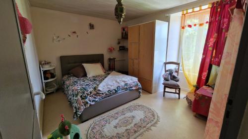 une petite chambre avec un lit et une chaise dans l'établissement Les Mésanges, à Vançais