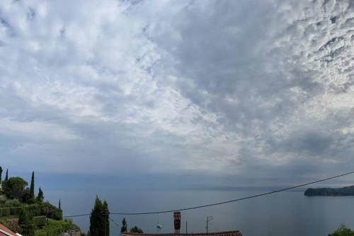 a cloudy sky with a traffic light and a body of water at Sunrise SeaView Apartment Fiesa in Piran