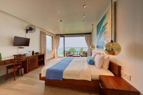 a bedroom with a bed with a desk and a window at Agnus Unawatuna in Unawatuna
