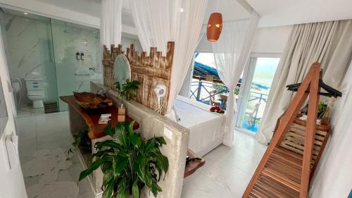 a bathroom with a bath tub and a toilet at Sollaris Ecopousada in Japaratinga