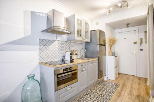 une cuisine avec des armoires blanches et un four à plaques de cuisson dans l'établissement STUDIO AVEC ESPACE NUIT EN PLEIN CENTRE DE DEAUVILLE, à Deauville