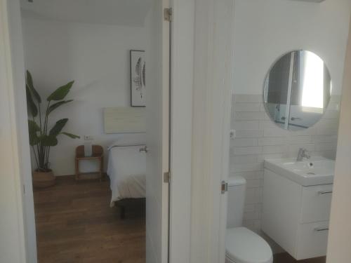 a bathroom with a toilet and a sink and a mirror at Apartamentos Cala San Pedro in Las Negras
