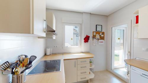 eine Küche mit weißen Schränken und einem Herd mit Backofen in der Unterkunft Casa Quisqueya - A Murcia Holiday Rentals Property in Roldán