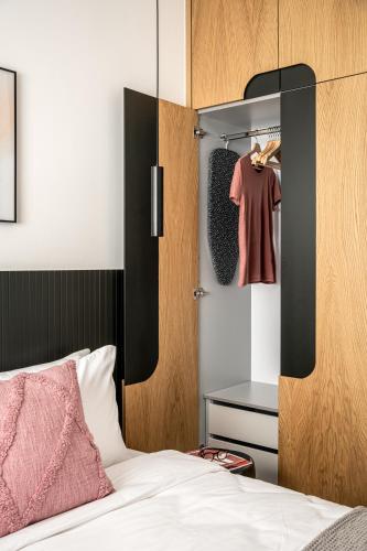 a bedroom with a bed and a wardrobe with a red shirt at Mate GEORGE - By HOMY in Tel Aviv