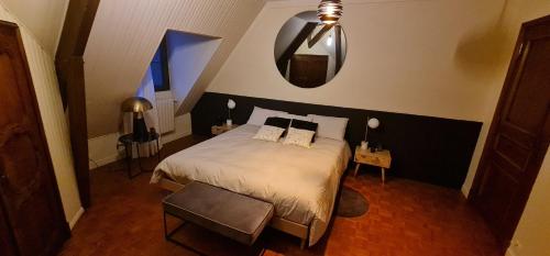 1 dormitorio con cama y espejo en la pared en Manoir de la Sauldre, en Argent-sur-Sauldre