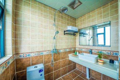 y baño con lavabo y ducha. en Yixun Inn en Zhangjiajie