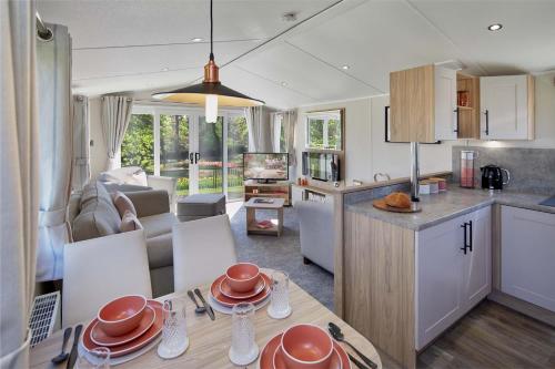 a kitchen and living room with a table and chairs at Springwood Holiday Park in Kelso