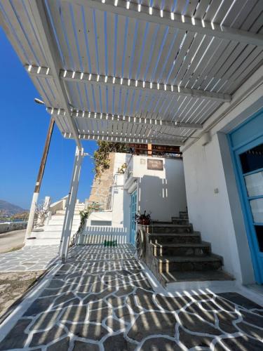 a white building with a blue door and stairs at Maya Mallis in Adamas