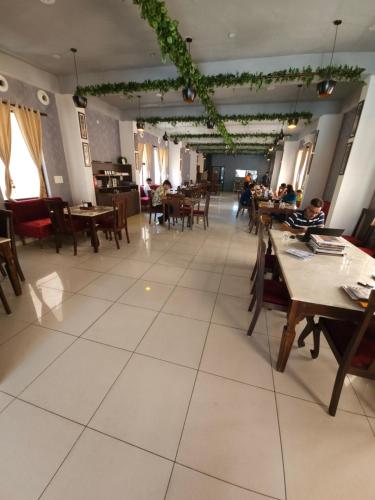 a restaurant with tables and people sitting at tables at Pink Vista Hotel in Jaipur