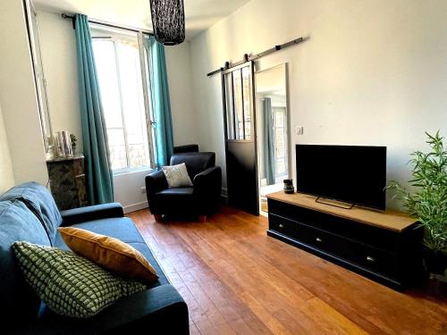 ein Wohnzimmer mit einem Sofa und einem Flachbild-TV in der Unterkunft Appartement cosy et lumineux centre-ville #4 in Dreux