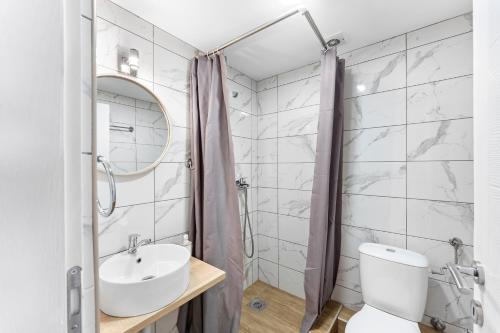 bagno con lavandino, servizi igienici e specchio di M Apartments a Soko Banja