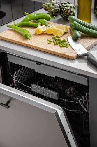 an open dishwasher with a cutting board and vegetables at Mate GEORGE - By HOMY in Tel Aviv