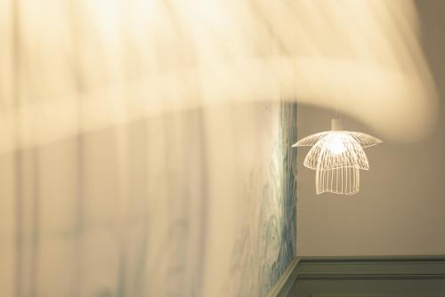 a light hanging from a wall next to a curtain at Manoir de Laroque Delprat in Autoire