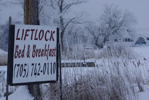 a sign in the snow next to a fence at Liftlock Guest House in Peterborough