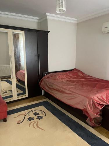 een slaapkamer met een bed en een spiegel bij Deniz Gören Geniş Aile İçin Uygun Daire in Antalya