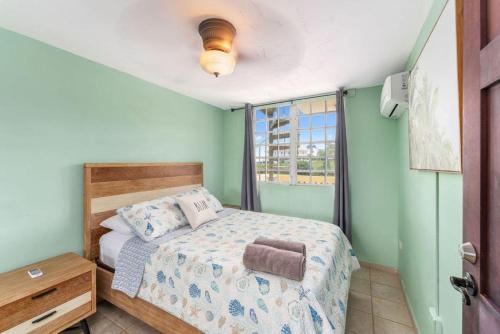 een kleine slaapkamer met een bed en een raam bij Puntas Rincon Villa 301 with private rooftop terrace in Rincon