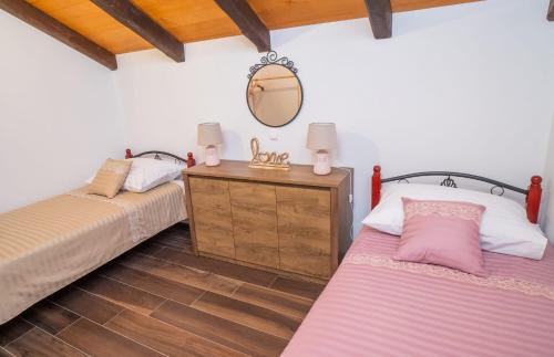2 Betten in einem Zimmer mit Spiegel in der Unterkunft Villa Ilir in Neum