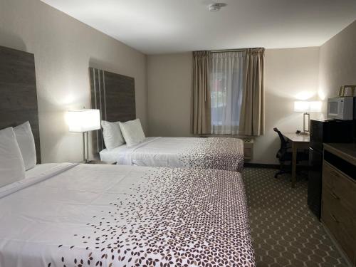 a hotel room with two beds and a desk at Dillon Inn in Dillon