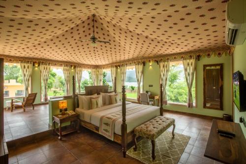 a bedroom with a bed in a room with windows at Ratan Villas Sariska in Alwar